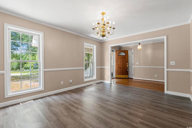 Unfurnished room featuring a chandelier, healthy amount of natural light, wood finished floors, and crown molding | Image 29