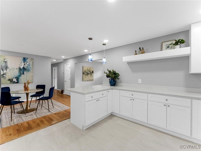 Kitchen featuring open shelves, hanging light fixtures, a peninsula, and light countertops | Image 19