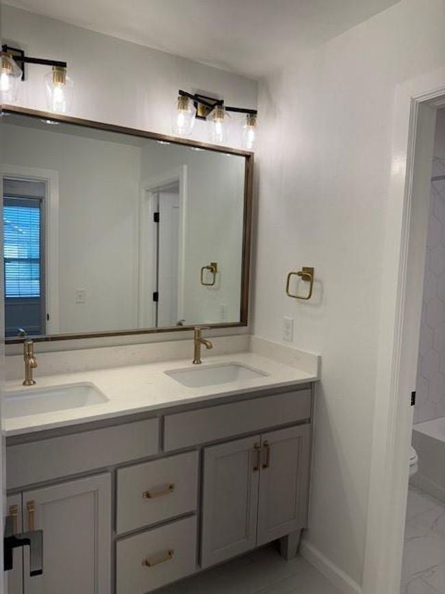Full bathroom featuring toilet, marble finish floor, a sink, and double vanity | Image 30