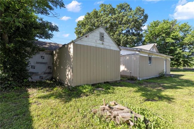 View of side of property with a storage unit and a yard | Image 26