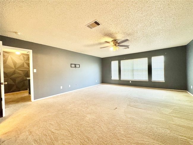 Carpeted spare room featuring a ceiling fan and a textured ceiling | Image 14