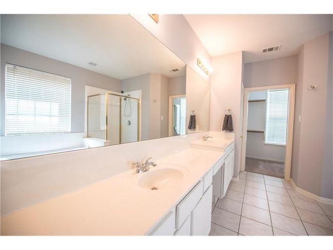Full bathroom with double vanity, tile patterned flooring, a stall shower, and baseboards | Image 15
