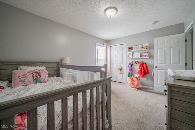 Bedroom with a textured ceiling, a closet, and light colored carpet | Image 18