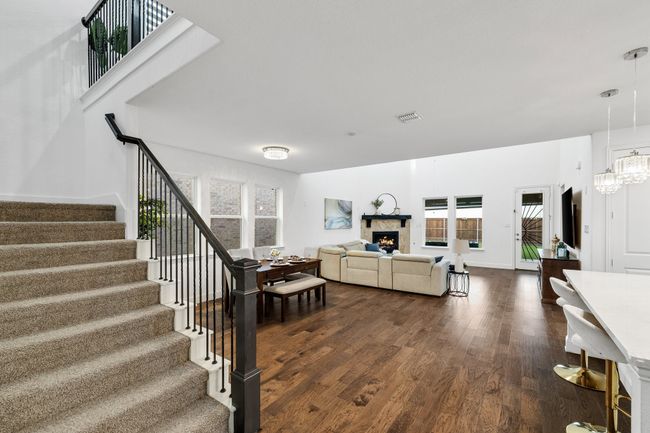 Living room with dark wood-type flooring, a premium fireplace, and an inviting chandelier | Image 4