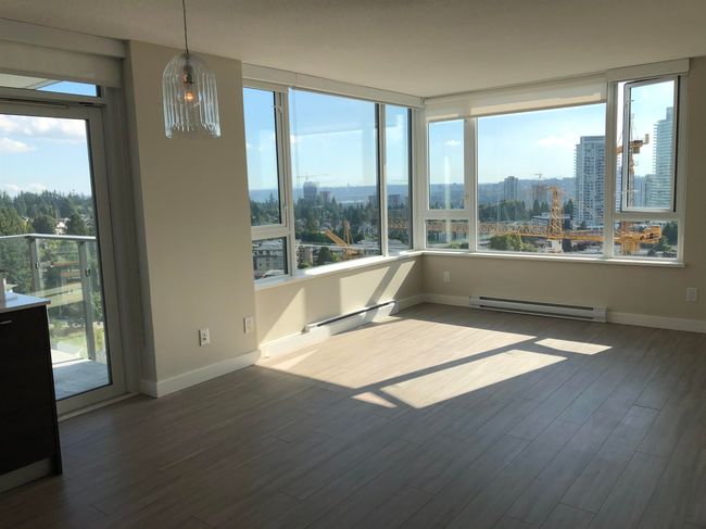 Empty room featuring a view of city, baseboards, a baseboard heating unit, and dark wood-style floors | Image 15