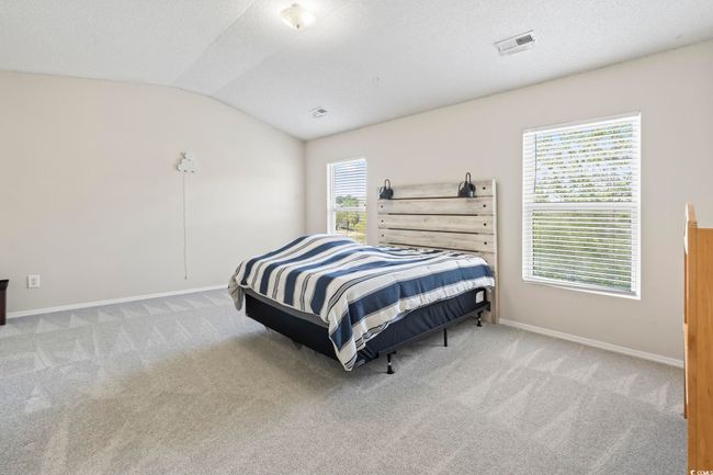 Carpeted bedroom featuring lofted ceiling, baseboards, and a textured ceiling | Image 13