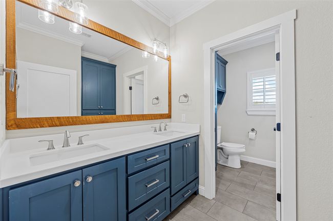 Bathroom with a sink, toilet, double vanity, and crown molding | Image 18