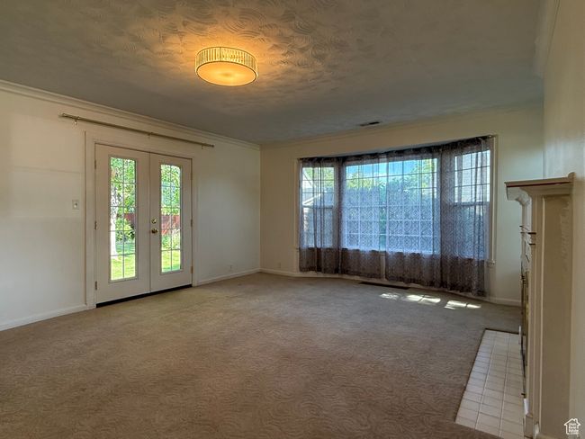 Unfurnished room with healthy amount of natural light, baseboards, french doors, carpet, and ornamental molding | Image 17