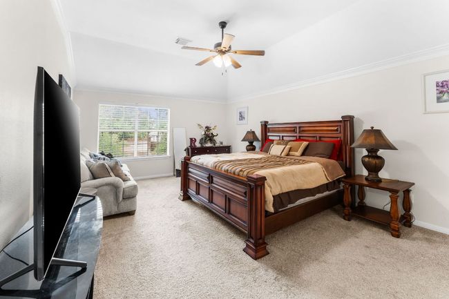 Bedroom featuring light carpet, baseboards, ornamental molding, and ceiling fan | Image 18