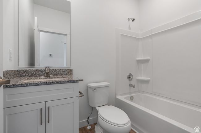 Full bathroom with toilet, vanity, baseboards, and shower / washtub combination | Image 7
