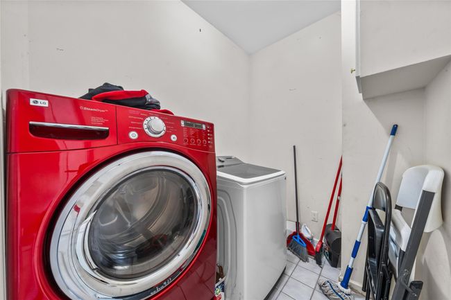 Clothes washing area with tile patterned floors, washer and dryer, and laundry area | Image 39
