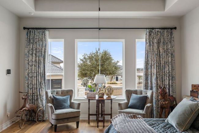 Bedroom with a raised ceiling, multiple windows, wood finished floors, and baseboards | Image 27