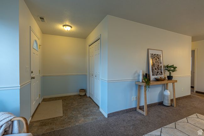 Entryway with baseboards, carpet flooring, a textured ceiling, and visible vents | Image 5