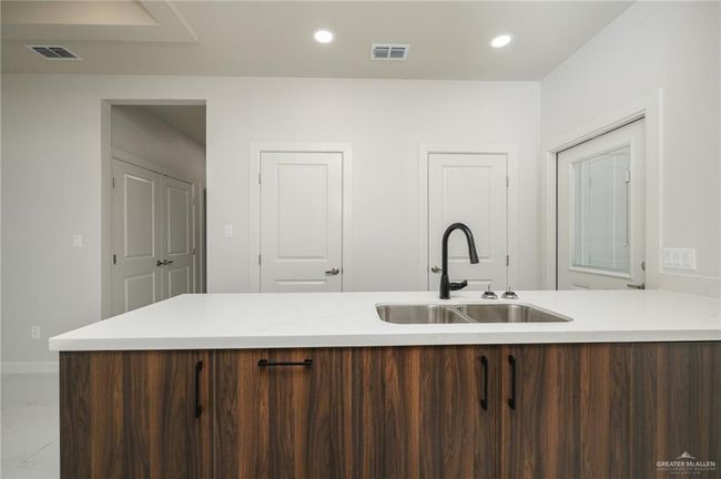 Kitchen featuring a sink, light countertops, baseboards, recessed lighting, and marble finish floors | Image 9