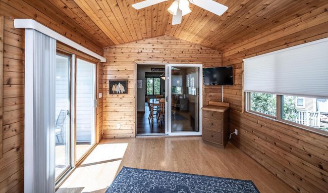 Another view of four-season porch with sliding doors to dining room and custom deck. *(includes mounted 34-inch Sony flat screen TV). | Image 14