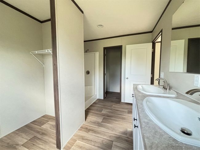 Full bath featuring ornamental molding, wood look finished floors, and double vanity | Image 10