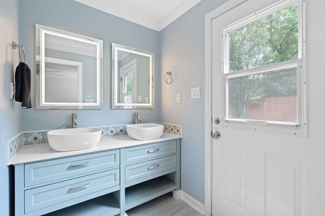 Primary bathroom featuring double vanity, double rain head showers, free standing deep soaking tub. | Image 22