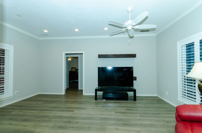 Living area with a ceiling fan, crown molding, wood finished floors, and recessed lighting | Image 7