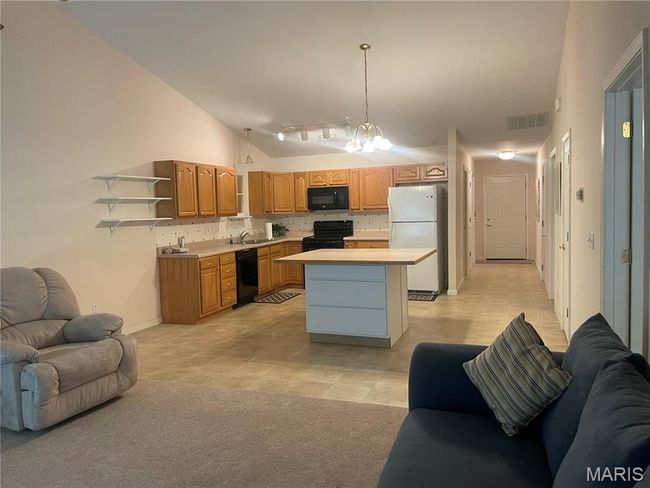 Kitchen featuring black appliances, open floor plan, a sink, open shelves, and light countertops | Image 11