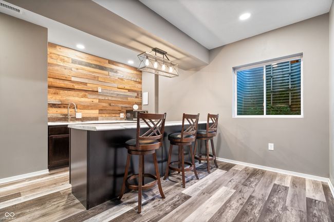 Wet bar in the basement complete with an under counter beverage cooler and seating at the bar area. | Image 20