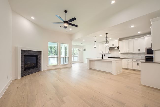 Kitchen with open floor plan, wall oven, a ceiling fan, recessed lighting, and tasteful backsplash | Image 5