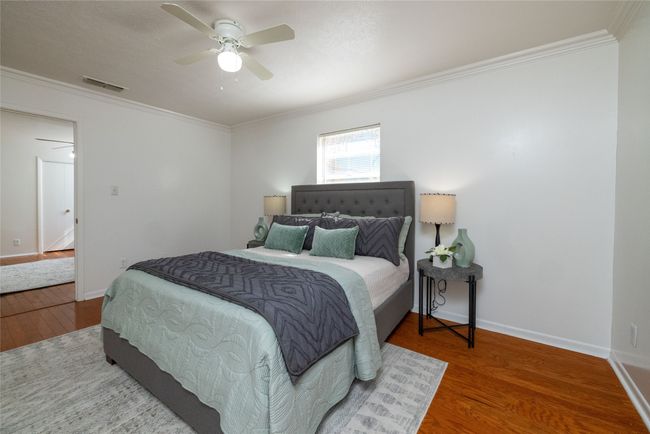 Bedroom featuring wood finished floors, crown molding, baseboards, and ceiling fan | Image 8