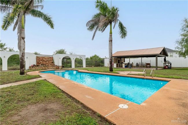 View of swimming pool featuring a patio and a lawn | Image 6