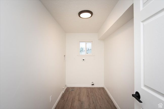 Washroom featuring baseboards, laundry area, electric dryer hookup, and wood finished floors | Image 16