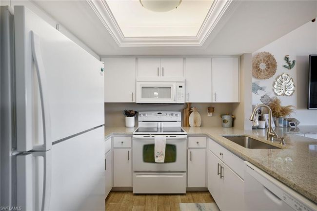 Kitchen with white cabinetry, sink, white appliances, and crown molding | Image 9