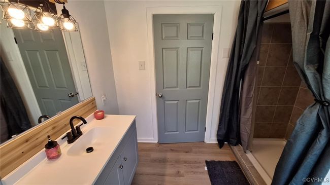 Bathroom with vanity, a stall shower, and wood finished floors | Image 36