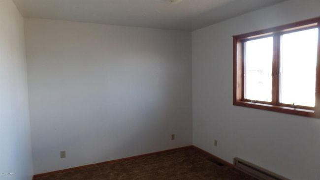 Carpeted bedroom with baseboard heating and a wealth of natural light | Image 26