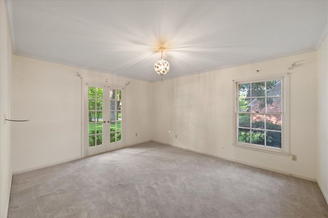 Front bedroom featuring healthy amount of natural light, crown molding, french doors, and a chandelier with bathroom | Image 26