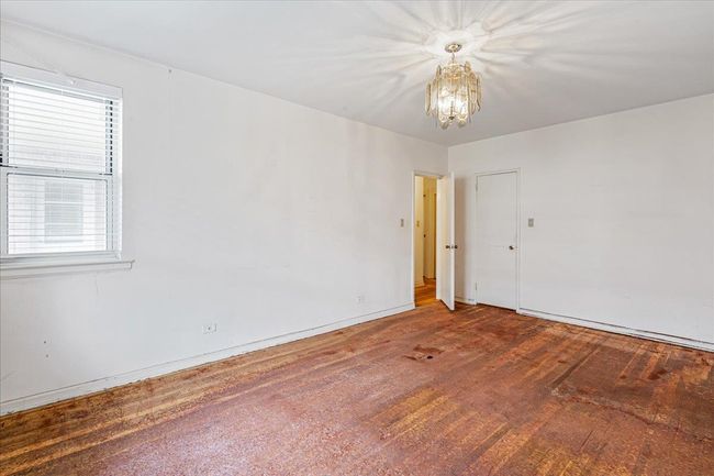 Empty room with a chandelier, wood finished floors, and plenty of natural light | Image 13