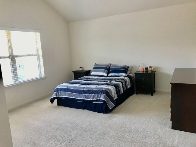 Carpeted bedroom featuring baseboards and lofted ceiling | Image 10