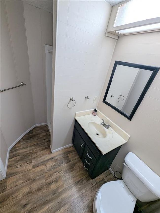 Bathroom featuring wood finished floors, toilet, vanity, and baseboards | Image 28