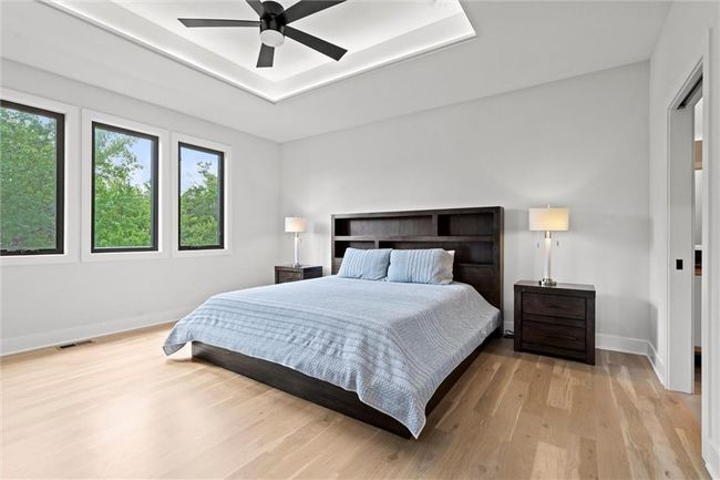 Bedroom with light wood finished floors and a ceiling fan | Image 18