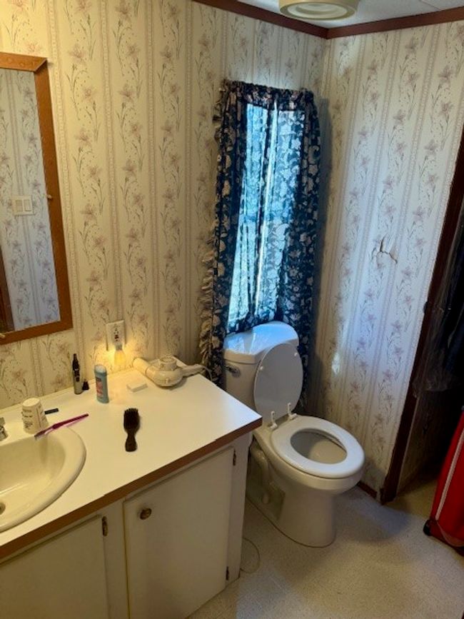 Half bath with wallpapered walls, vanity, and toilet | Image 24