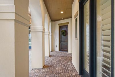 Features include recessed lighting, beautiful arched openings overlooking a courtyard with covered Pergola and charming brick flooring. This home comes complete with a TAEXX "tubes in the wall" pest control system and new water heaters were installed in 2024. | Image 3