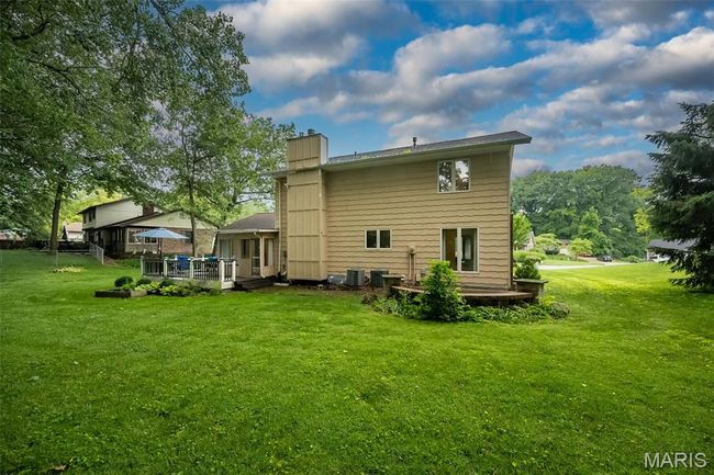 Back of property with a chimney, a lawn, and a deck | Image 35
