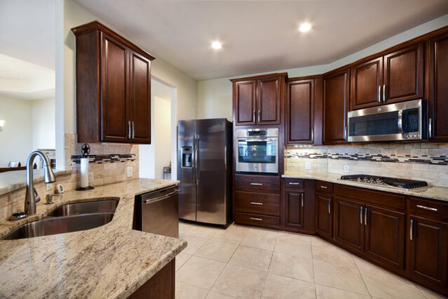 Kitchen with stainless steel appliances, a sink, tasteful backsplash, light stone countertops, and recessed lighting | Image 9