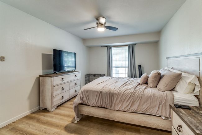 Bedroom with light wood-type flooring, a ceiling fan, and baseboards | Image 16