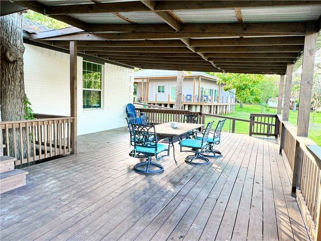 Wooden deck with a yard and outdoor dining space | Image 25