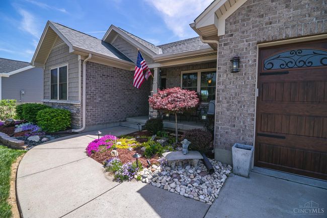 View of the covered front porch. Professional landscaping including low voltage lighting system. Brick, stone, shake elevation. | Image 48