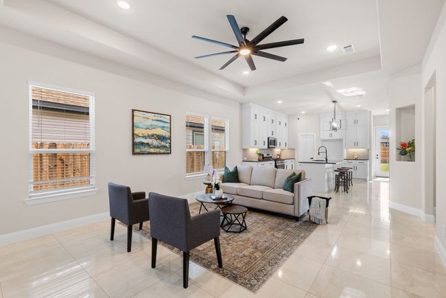 Living room featuring light tile patterned flooring, baseboards, visible vents, and ceiling fan | Image 14