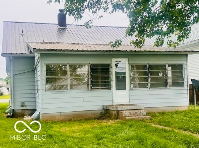 view of side of property featuring fence, cooling unit, a ceiling fan, a lawn, and a porch | Image 19