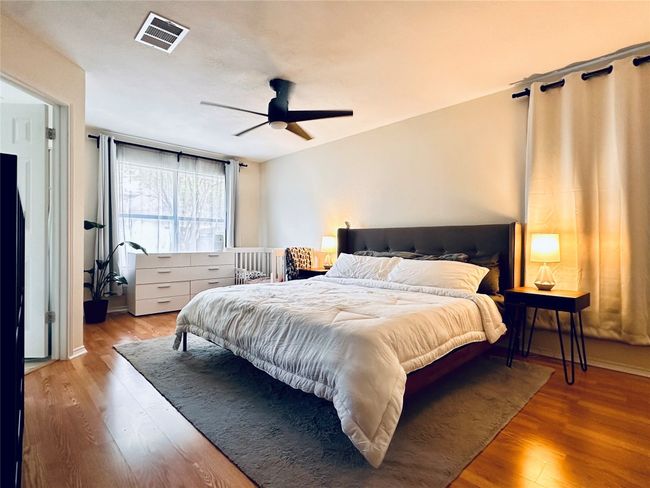 Bedroom featuring visible vents, a ceiling fan, and wood finished floors | Image 13