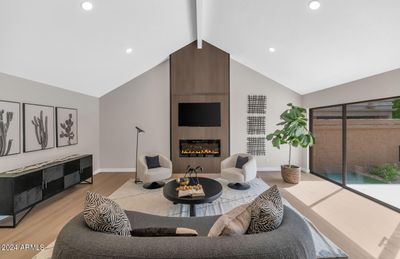 This stunning living room features vaulted ceilings that create an open and airy ambiance, enhanced by recessed lighting and large windows that allow natural light to flood the space. The sleek, modern fireplace serves as a striking focal point with its elegant design, perfect for cozy evenings. The expansive sliding glass doors offer seamless indoor-outdoor flow, leading directly to the backyard, ideal for entertaining or relaxing. Neutral tones and clean lines throughout make this space versatile and inviting, ready for customization to suit your personal style. | Image 2