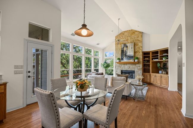 From the breakfast area, enjoy a view back into the spacious living room and sunlit windows. The door opens to the screened porch and then the deck, offering an easy indoor-outdoor flow. | Image 11