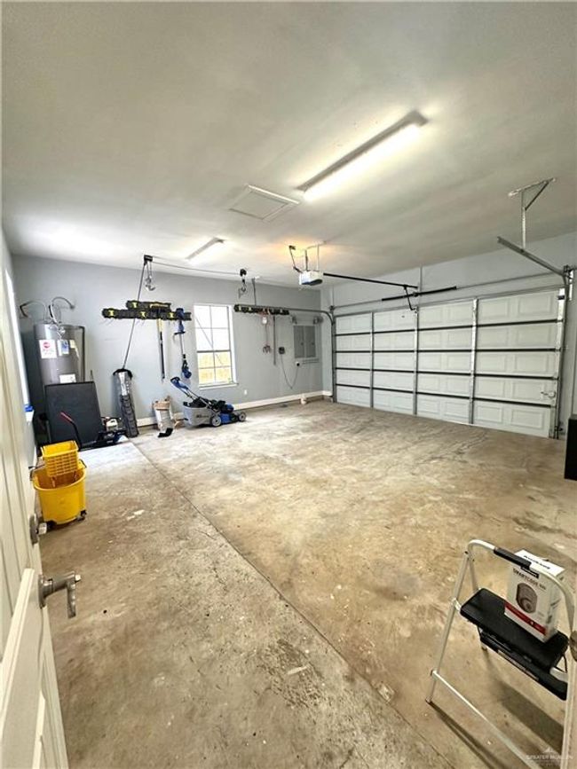 Garage with a garage door opener and water heater | Image 24