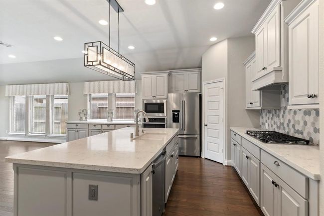 Beautiful Light Fixture over Island with Dishwasher. Gas Cooktop makes for a great Chef's Kitchen. Kitchen Cabinets have Pull Out Drawers, that were added. | Image 10
